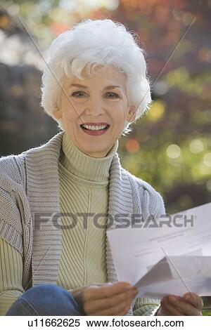 Portrait of senior woman holding mail outdoors View Large Photo Image Stock Photography - Portrait of senior woman holding mail outdoors. Fotosearch