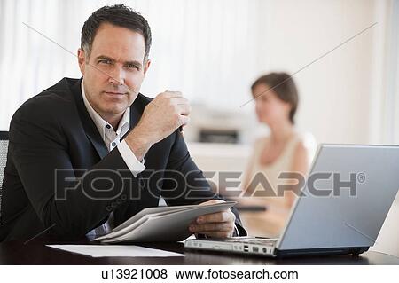 Stock Photo - Portrait of successful mature businessman working in office. Fotosearch