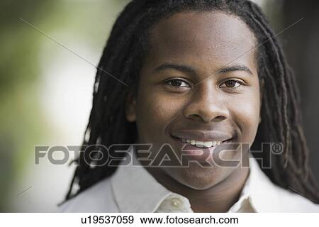 Stock Photo - "Portrait of teenage boy (16-17) with dreadlocks, smiling". Fotosearch