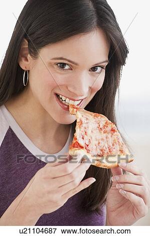 Stock Photo - Portrait of woman eating pizza slice. Fotosearch