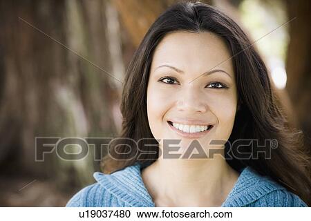 Stock Image - Portrait of woman in park. Fotosearch