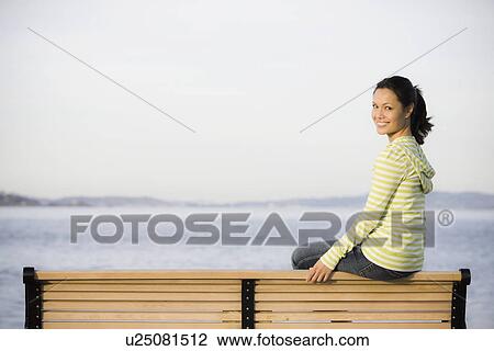 Portrait of woman relaxing on bench near sea View Large Photo Image Stock Image - Portrait of woman relaxing on bench near sea. Fotosearch