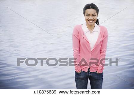 Stock Photo - Portrait of woman smiling by sea. Fotosearch