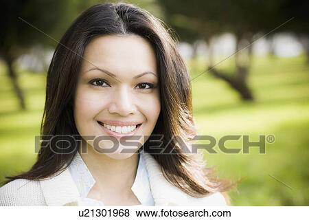 Stock Photo - Portrait of woman smiling in park. Fotosearch