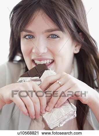 Portrait of young woman eating chocolate View Large Photo Image Stock Image - Portrait of young woman eating chocolate. Fotosearch