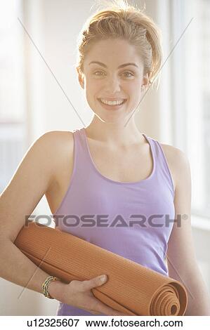 Portrait of young woman holding exercise mat View Large Photo Image Stock Photo - Portrait of young woman holding exercise mat. Fotosearch