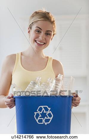 Portrait of young woman holding recycling bin View Large Photo Image Stock Photograph - Portrait of young woman holding recycling bin. Fotosearch