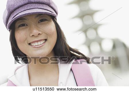 Stock Image - "Portrait of young woman smiling, outdoors". Fotosearch
