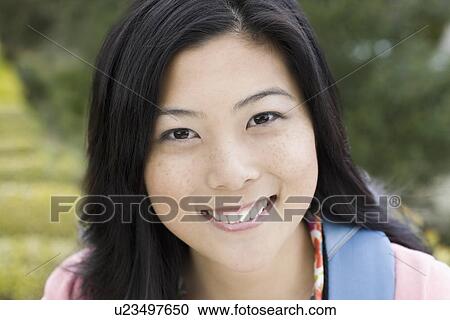 Stock Image - "Portrait of young woman smiling, outdoors". Fotosearch