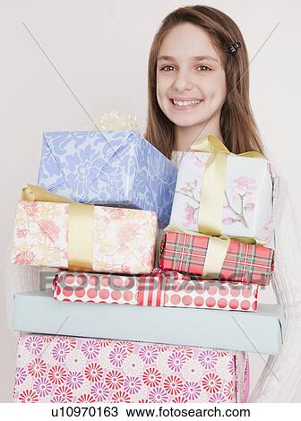 "Preteen girl (10-12 years) with stack of birthday presents, smiling, portrait" View Large Photo Image Stock Image - "Preteen girl (10-12 years) with stack of birthday presents, smiling, portrait". Fotosearch
