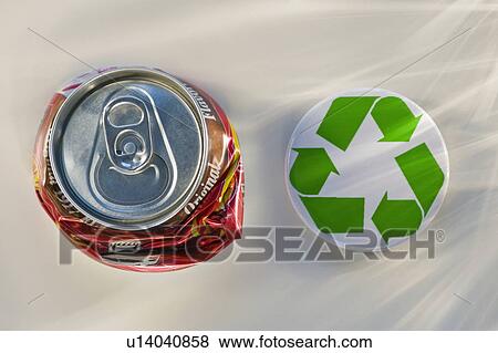 Stock Photo - "Recycling sign beside crushed can, studio shot". Fotosearch