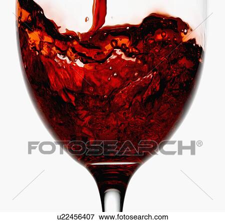 Stock Photo - "Red wine being poured into wineglass, close-up". Fotosearch