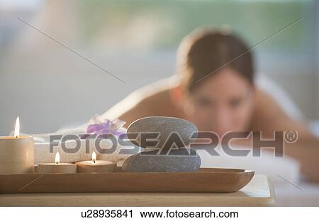 Rocks and candles on tray with woman lying in background View Large Photo Image Stock Image - Rocks and candles on tray with woman lying in background. Fotosearch