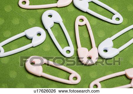 Stock Photograph - Safety pins on green background. Fotosearch