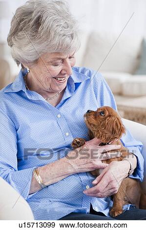 Stock Photo - Senior woman hugging puppy. Fotosearch