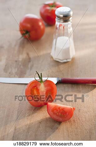 "Sliced tomato, knife and salt cellar" View Large Photo Image Stock Photo - "Sliced tomato, knife and salt cellar". Fotosearch