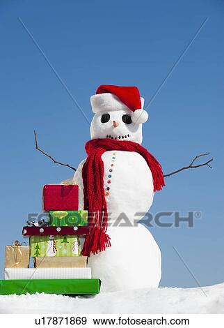 Stock Photo - "Snowman and Christmas presents, clear sky in background". Fotosearch