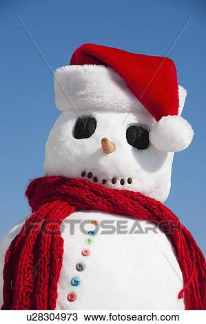 Stock Image - Snowman wearing Santa hat. Fotosearch