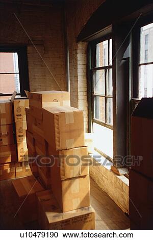 Stock Image - Stacked cardboard boxed in house. Fotosearch