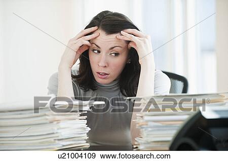 Stressed business woman observing paperwork in office View Large Photo Image Stock Photo - Stressed business woman observing paperwork in office. Fotosearch