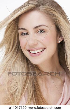Stock Image - Studio portrait of young woman smiling. Fotosearch