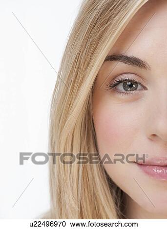 Stock Image - Studio portrait of young woman smiling. Fotosearch