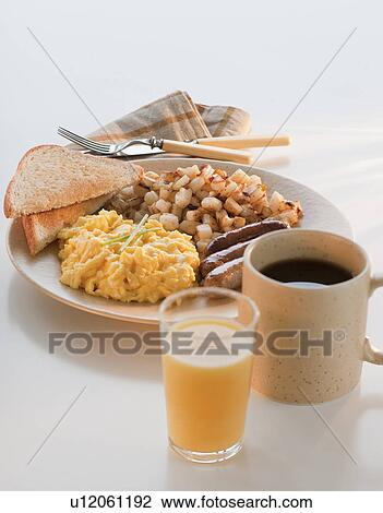 Stock Image - Studio shot of breakfast including eggs with sausages and potatoes. Fotosearch