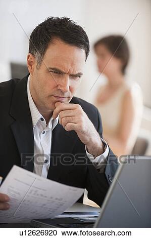Stock Image - Successful mature businessman working in office. Fotosearch