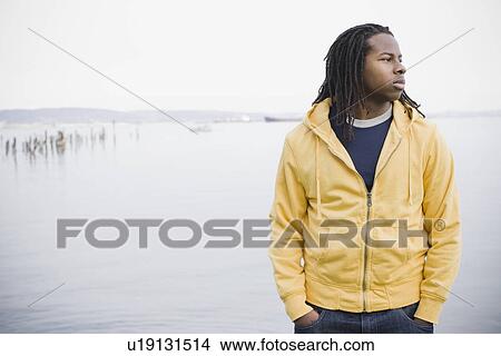 Picture - "Teenage boy (16-17) with dreadlocks, standing at waterfront, San Francisco, California, USA". Fotosearch
