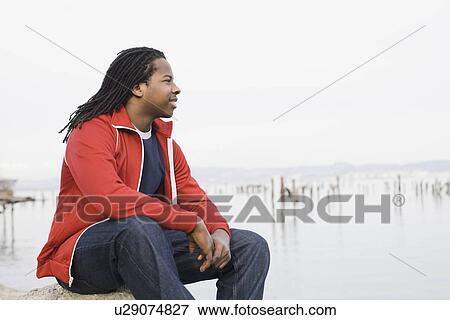 "Teenage boy (16-17) with dreadlocks, sitting at waterfront, San Francisco, California, USA" View Large Photo Image Stock Photo - "Teenage boy (16-17) with dreadlocks, sitting at waterfront, San Francisco, California, USA". Fotosearch