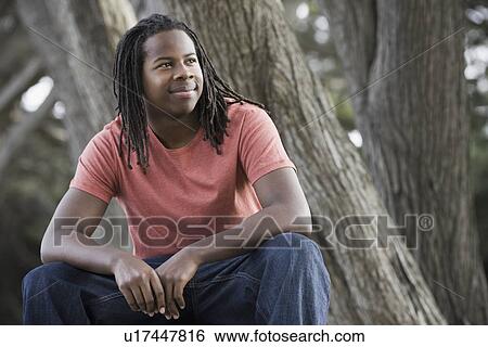 "Teenage boy (16-17) with dreadlocks, sitting in park" View Large Photo Image Stock Photograph - "Teenage boy (16-17) with dreadlocks, sitting in park". Fotosearch