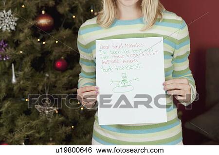Teenage girl (13-15) holding Christmas card View Large Photo Image Stock Photograph - Teenage girl (13-15) holding Christmas card. Fotosearch