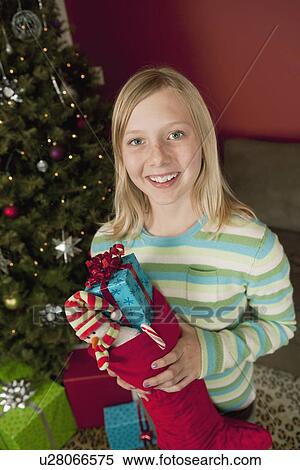 "Teenage girl (13-15) holding Christmas presents in Christmas stocking, portrait" View Large Photo Image Stock Photography - "Teenage girl (13-15) holding Christmas presents in Christmas stocking, portrait". Fotosearch