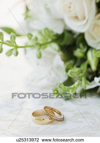 "Two wedding rings by bouquet of flowers, studio shot" View Large Photo Image Stock Image - "Two wedding rings by bouquet of flowers, studio shot". Fotosearch