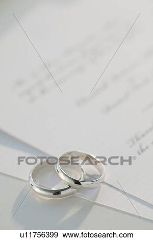 Stock Photo - "Two wedding rings on marriage certificate, studio shot". Fotosearch