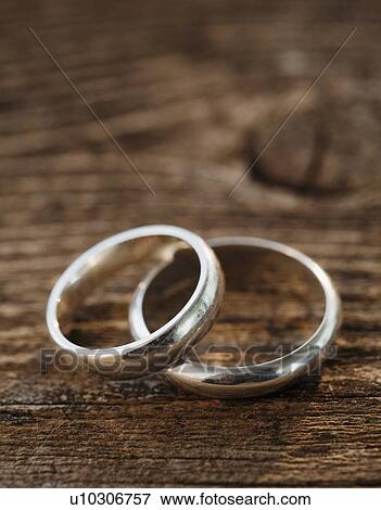 Stock Photo - Two wedding rings on wooden table. Fotosearch