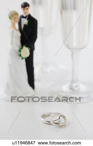 Wedding rings by bride and groom cake toppers and wineglasses View Large Photo Image Stock Photo - Wedding rings by bride and groom cake toppers and wineglasses. Fotosearch