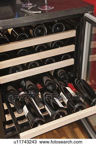 Stock Image - Wine bottles in wine cooler. Fotosearch