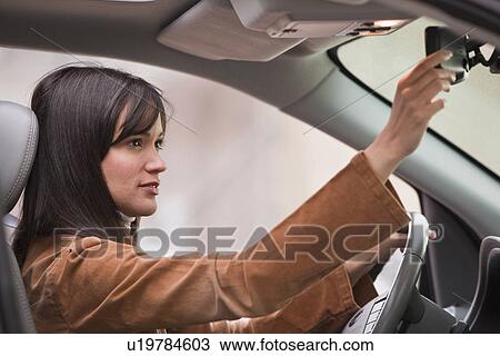 Woman adjusting rear view mirror View Large Photo Image Stock Image - Woman adjusting rear view mirror. Fotosearch