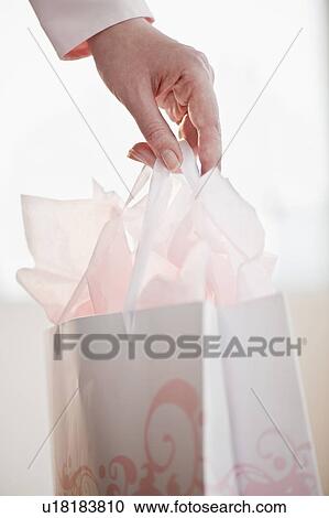 "Woman holding gift bag, close-up" View Large Photo Image Stock Image - "Woman holding gift bag, close-up". Fotosearch