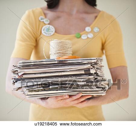 Stock Photography - Woman holding pile of old newspapers. Fotosearch