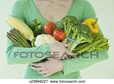 Stock Photo - Woman holding various vegetables. Fotosearch