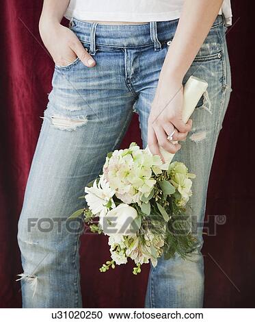 Woman in jeans holding bouquet of flowers View Large Photo Image Stock Image - Woman in jeans holding bouquet of flowers. Fotosearch