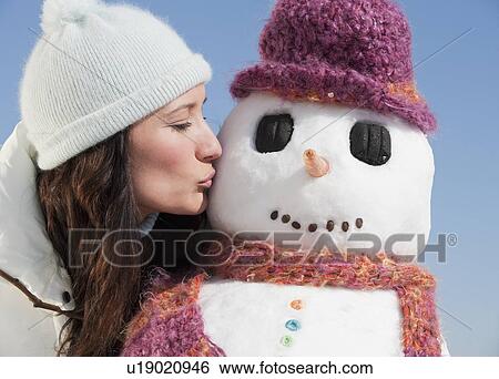 Stock Photograph - Woman kissing snowman. Fotosearch