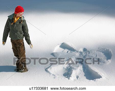 Woman looking at snow angel shape View Large Photo Image Stock Image - Woman looking at snow angel shape. Fotosearch