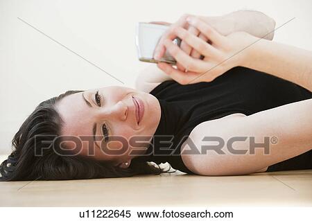 "Woman lying on floor using pda, studio shot" View Large Photo Image Stock Photography - "Woman lying on floor using pda, studio shot". Fotosearch