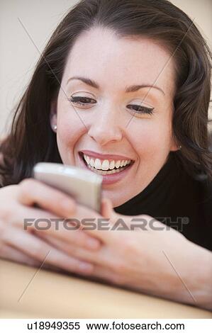 Stock Photography - "Woman lying on floor using pda, studio shot". Fotosearch