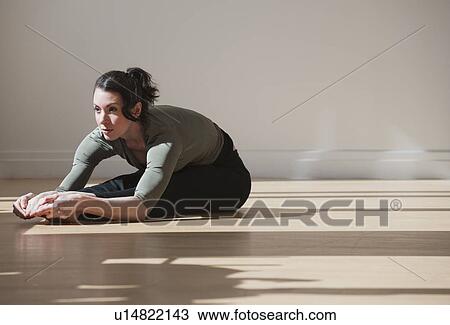 "Woman performing stretching exercise, studio shot" View Large Photo Image Stock Image - "Woman performing stretching exercise, studio shot". Fotosearch