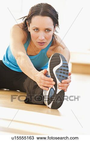Stock Image - Woman performing stretching exercises. Fotosearch