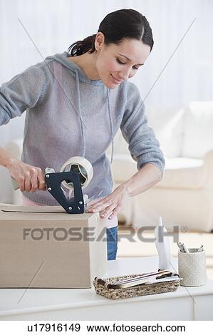 "Woman preparing parcel, smiling" View Large Photo Image Stock Photo - "Woman preparing parcel, smiling". Fotosearch
